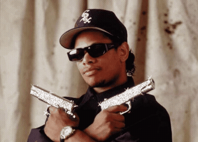 Man In Hat And Sunglasses Holding Two Guns GIF