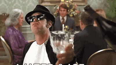 Man In Hat And Sunglasses Holding Wine At Table GIF