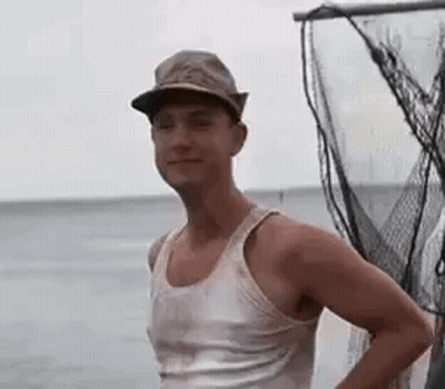 Man In Hat And Tank Top Standing By Fishing Net GIF