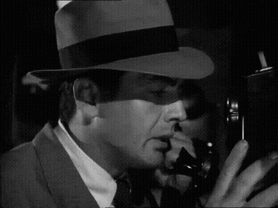 Man in Hat and Tie Taking Picture With Camera