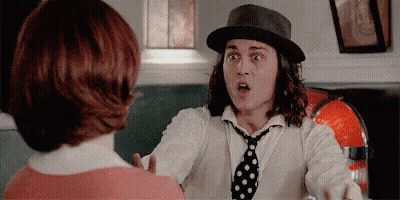 Man In Hat And Tie Talking To Woman In Red Shirt GIF