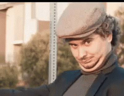 Man In Hat And Turtleneck Next To Stop Sign GIF