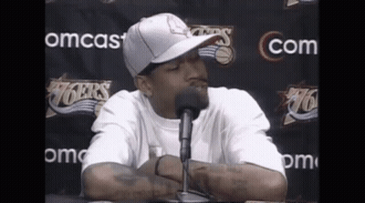 Man In Hat And White Shirt Talking Into Microphone GIF