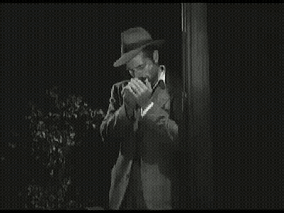 Man In Hat Covering Mouth Black And White GIF