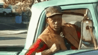 Man In Hat Driving Truck Down Street GIF