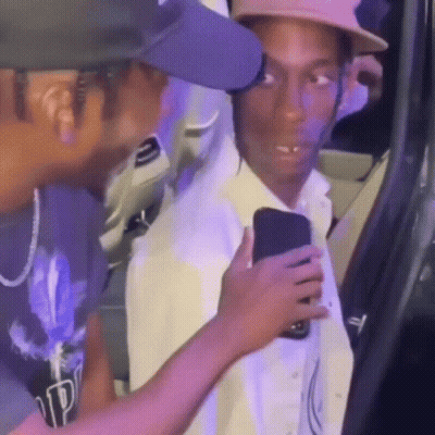 Man In Hat Holding Cell Phone Next To Another Man GIF