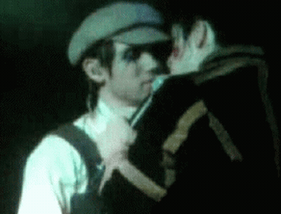 Man In Hat Holding Microphone To Another Man GIF