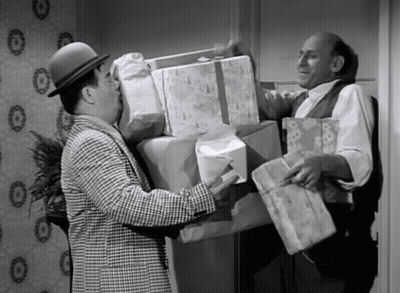 Man In Hat Holding Stack Of Gifts GIF