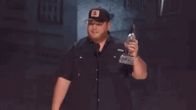 Man In Hat Holding Trophy Giving Middle Finger GIF
