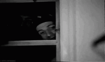 Man In Hat Peeking Out Window GIF