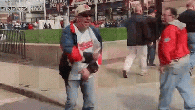 Man In Hat Saying Indians Walking Down Street GIF