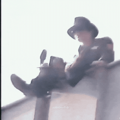 Man In Hat Sitting On Ledge With Legs Crossed GIF