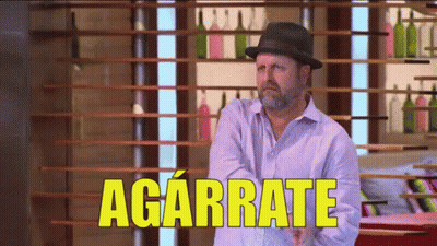 Man In Hat Standing Before Agárrate Sign GIF