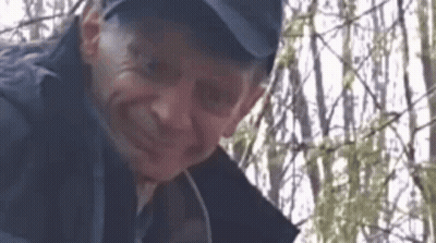Man In Hat Standing Before Fence GIF