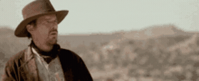 Man In Hat Standing In Desert GIF