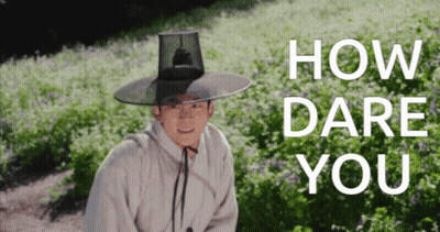 Man In Hat Standing In Flower Field Saying How Dare You GIF