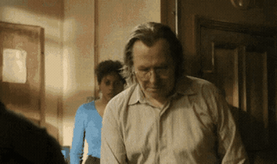 Man In Hat Standing In Front Of Agárrate Sign GIF