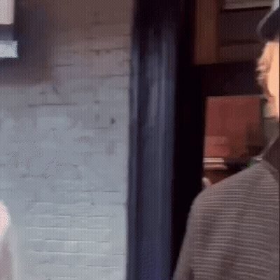Man In Hat Standing In Front Of Brick Wall GIF