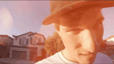 Man In Hat Standing In Front Of Large House GIF