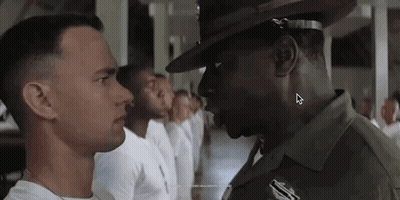Man In Hat Standing Next To Another Man In Line GIF