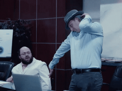 Man In Hat Standing Next To Man In White Coat GIF