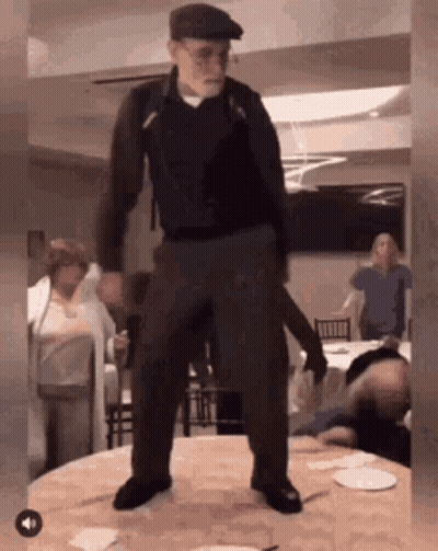 Man In Hat Standing On Table GIF
