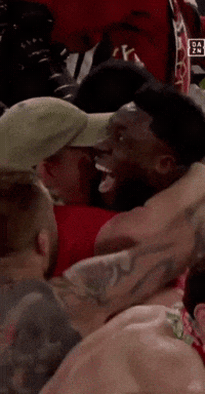 Man In Hat Surrounded By Other Men GIF