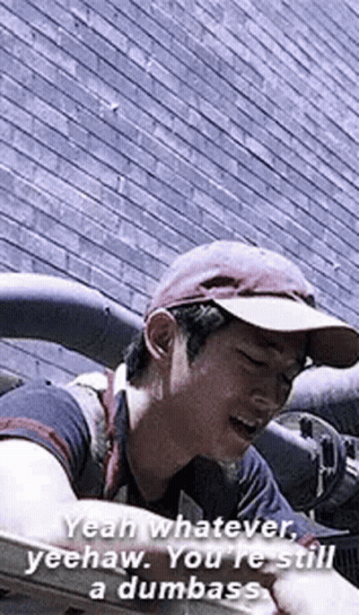 Man In Hat Talking In Front Of Brick Wall GIF