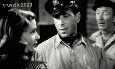 Man In Hat Talks To Woman In Black And White Photo GIF