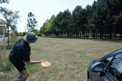 Man In Hat Throwing Frisbee In Grassy Field GIF