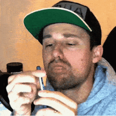 Man In Hat With Letter A Holding Something GIF
