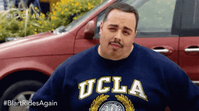 Man In Hat With Letter M Standing In Crowd GIF