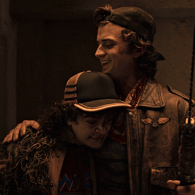 Man In Hat With W Hugging Jacketed Man GIF