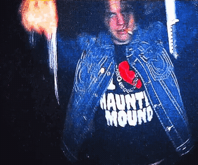 Man In Haunt Mound Shirt Holding Torch GIF