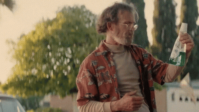 Man In Hawaiian Shirt Holding Green Bottle GIF