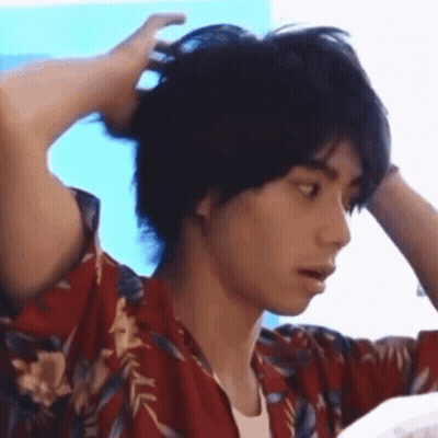 Man In Hawaiian Shirt Holding Hair In Bun GIF