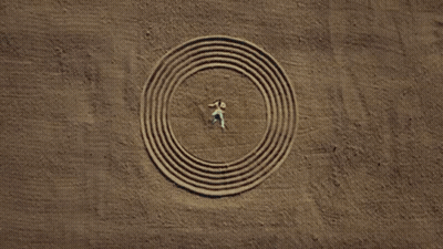 Man In Headband And Yellow Jacket In Desert GIF