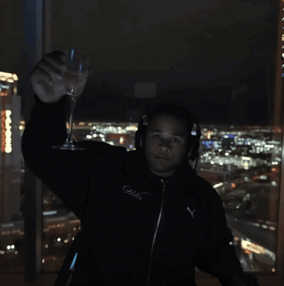 Man In Headphones And Black Puma Jacket Holding Wine Glass GIF