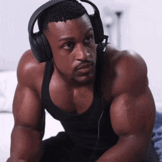 Man In Headphones And Black Tank Top Looking At Camera GIF