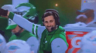 Man In Headphones And Green Jacket In Front Of Gatorade Cooler GIF