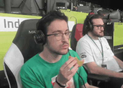 Man In Headphones And Green Shirt Eating Snack GIF