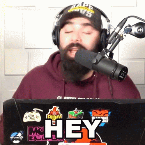 Man In Headphones And Hat Talking Into Microphone With Hey GIF