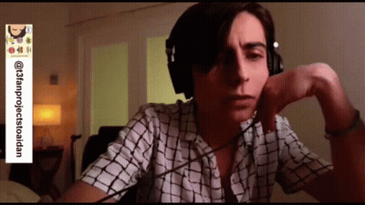 Man In Headphones And Plaid Shirt Sitting At Desk GIF