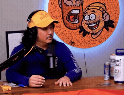 Man In Headphones And Yellow Hat With Liquid Death GIF