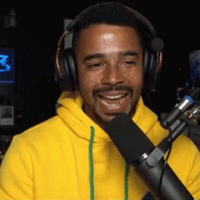 Man In Headphones And Yellow Hoodie Talking Into Microphone GIF
