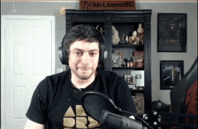 Man In Headphones At Microphone In Front Of Mr Llama Sign GIF