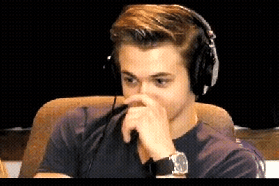 Man In Headphones Covering Nose With Hand GIF