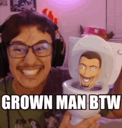 Man In Headphones Holding Toy In Toilet Grown Man BTW GIF