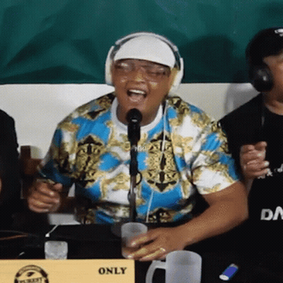 Man In Headphones Singing At Table With Only Sign GIF