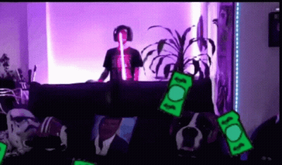 Man In Headphones Sits On Couch Surrounded By Money GIF